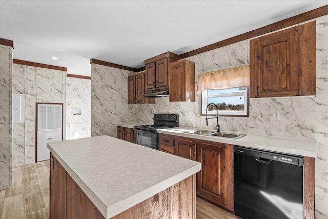 kitchen with black appliances, a sink, light countertops, under cabinet range hood, and a kitchen island