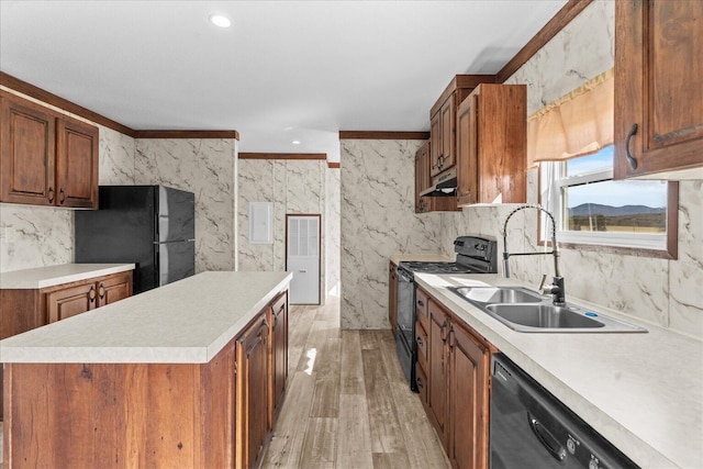 kitchen featuring black appliances, under cabinet range hood, a sink, light wood-style flooring, and light countertops