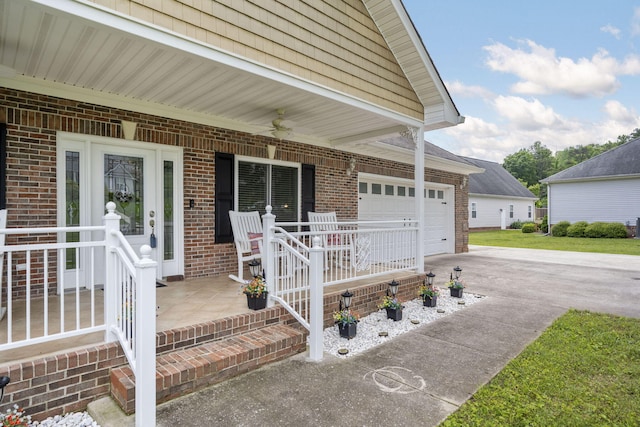 12204 Plow Ln, Soddy Daisy, TN 37379 - doorway to property with covered porch, concrete driveway, brick siding, an attached garage, and a ceiling fan