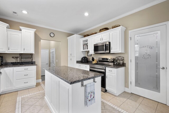 12204 Plow Ln, Soddy Daisy, TN 37379 - kitchen featuring stainless steel appliances, light tile patterned floors, white cabinetry, a center island, and crown molding