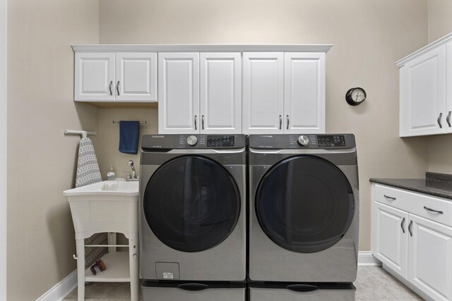 12204 Plow Ln, Soddy Daisy, TN 37379 - laundry room with cabinet space, washing machine and clothes dryer, baseboards, and light tile patterned floors