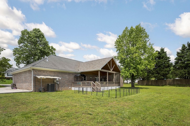 12204 Plow Ln, Soddy Daisy, TN 37379 - back of house featuring a sunroom, central AC unit, and brick siding