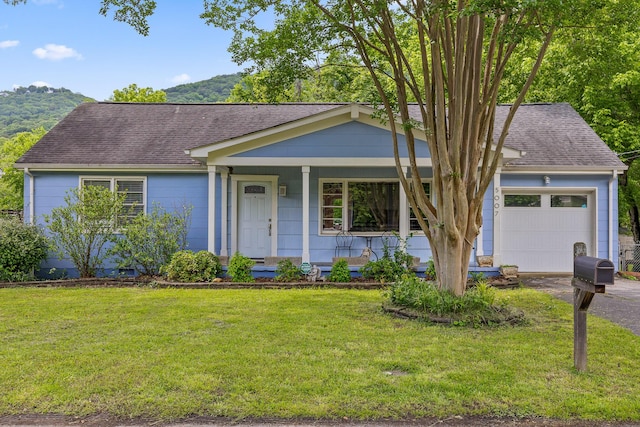 5007 Florida Ave, Chattanooga, TN 37409 - view of front of house with a front yard, a shingled roof, covered porch, and a garage