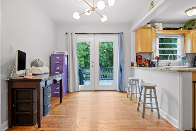 5007 Florida Ave, Chattanooga, TN 37409 - kitchen with light brown cabinetry, light wood-type flooring, a chandelier, and a kitchen breakfast bar