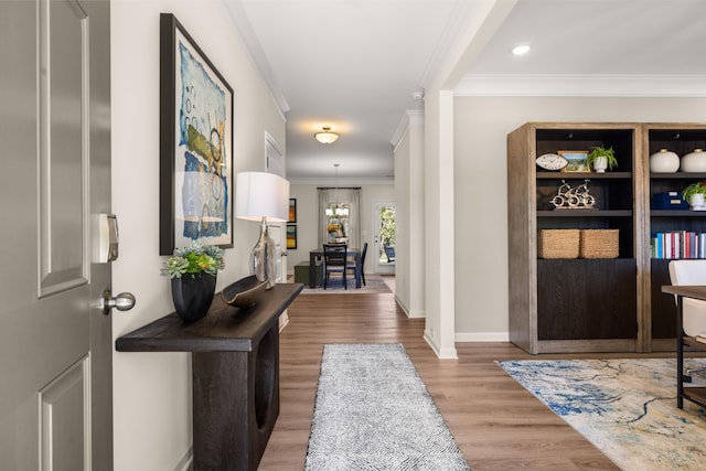 entryway with ornamental molding, wood finished floors, baseboards, a chandelier, and recessed lighting