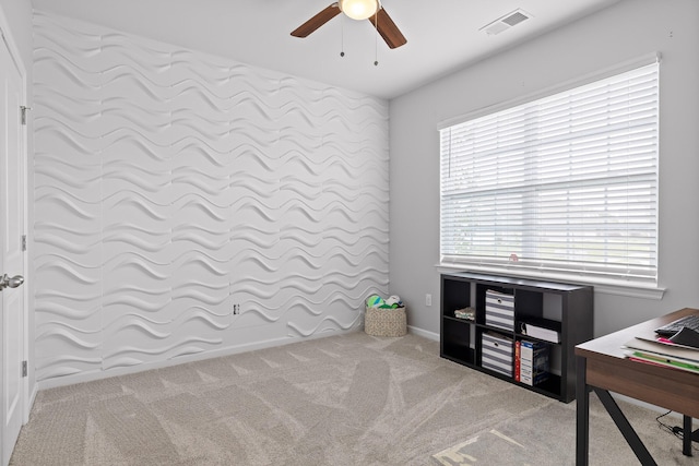 carpeted office space with a ceiling fan