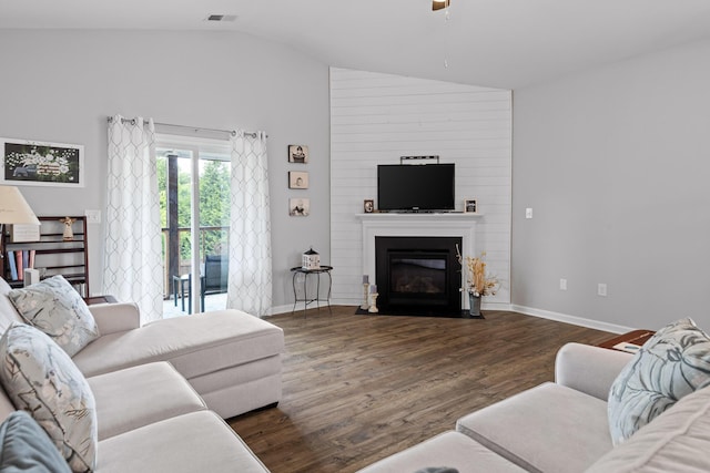 living area featuring vaulted ceiling, ceiling fan, wood finished floors, baseboards, and a large fireplace