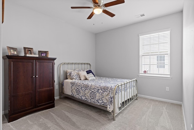 bedroom featuring light carpet, baseboards, and ceiling fan