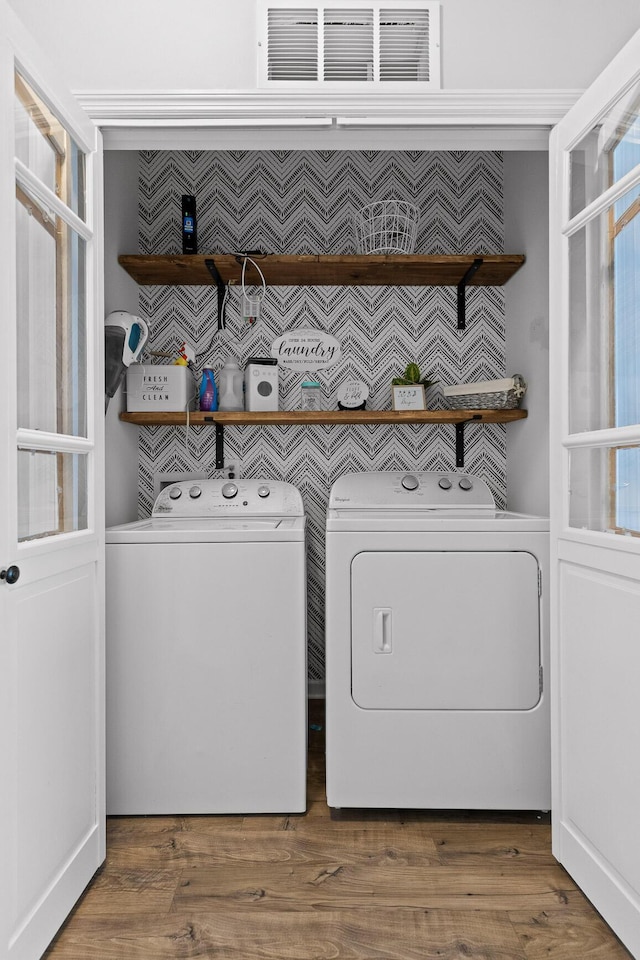 laundry area with washer and dryer and wood finished floors