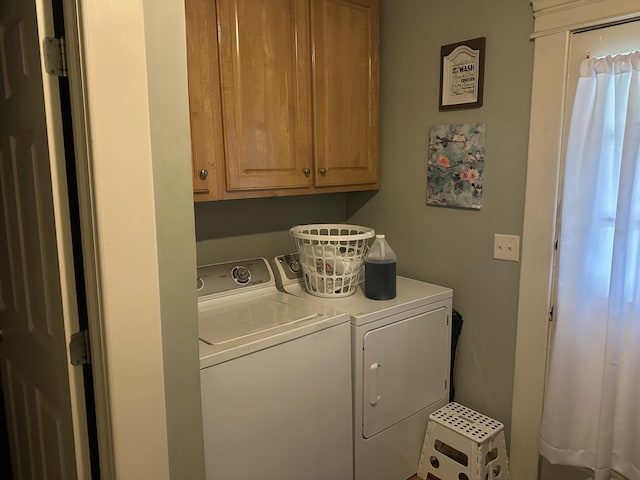 laundry room with washing machine and clothes dryer and cabinet space