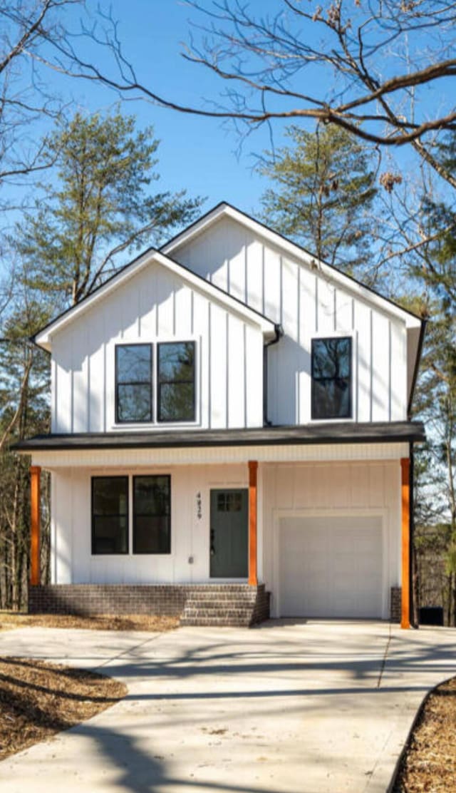 1924 Wilberforce St, Chattanooga, TN 37421 - view of front of house with concrete driveway, an attached garage, board and batten siding, and brick siding