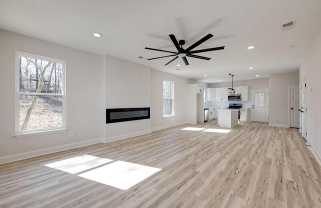 1924 Wilberforce St, Chattanooga, TN 37421 - unfurnished living room featuring light wood-style floors, a glass covered fireplace, recessed lighting, baseboards, and a ceiling fan