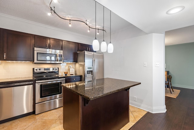 1131 Stringers Ridge Rd Unit 11G, Chattanooga, TN 37405 - kitchen with appliances with stainless steel finishes, ornamental molding, dark brown cabinets, a kitchen island, and tasteful backsplash