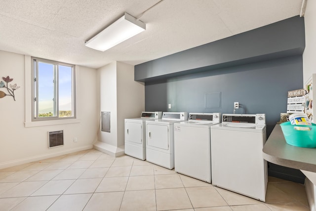 1131 Stringers Ridge Rd Unit 11G, Chattanooga, TN 37405 - community laundry featuring washer and clothes dryer, heating unit, baseboards, a textured ceiling, and light tile patterned flooring