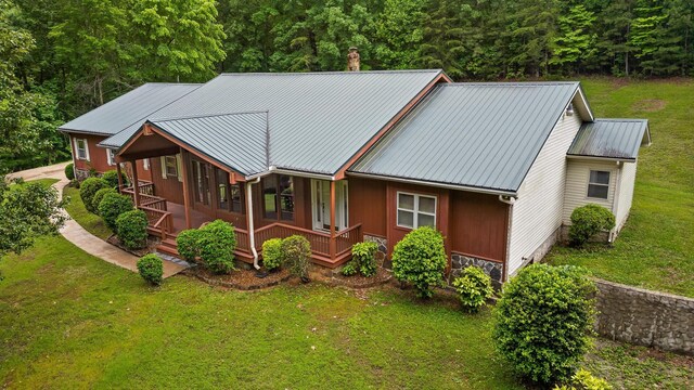 6601 Hunter Rd, Harrison, TN 37341 - view of front of home with a front yard, covered porch, metal roof, and a forest view