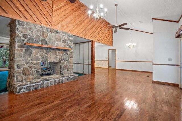 6601 Hunter Rd, Harrison, TN 37341 - unfurnished living room featuring a chandelier, a fireplace, a ceiling fan, wood finished floors, and vaulted ceiling