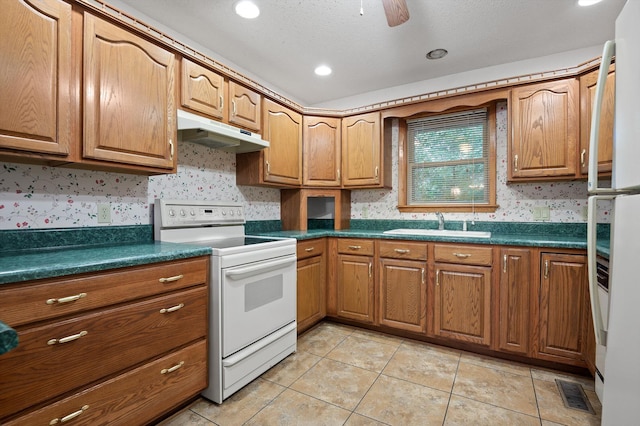 6601 Hunter Rd, Harrison, TN 37341 - kitchen featuring white electric range oven, under cabinet range hood, dark countertops, brown cabinetry, and wallpapered walls