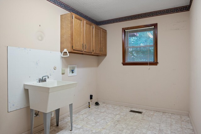 6601 Hunter Rd, Harrison, TN 37341 - laundry room featuring cabinet space, washer hookup, baseboards, a textured ceiling, and light flooring
