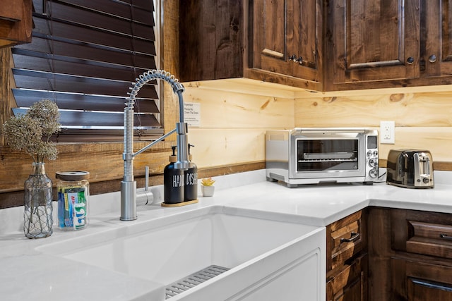 kitchen featuring a sink, light countertops, and dark brown cabinets