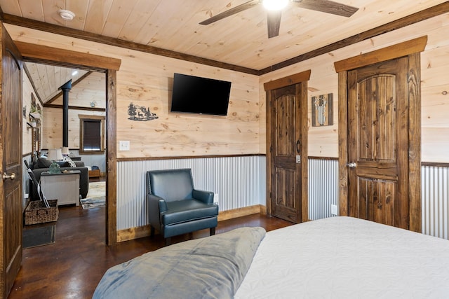 bedroom featuring wooden walls, a wood stove, wood ceiling, and wainscoting