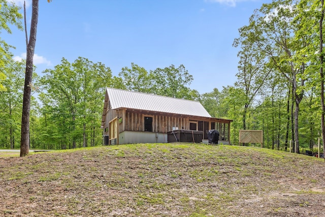 view of front of home with a pole building, metal roof, an outdoor structure, and board and batten siding