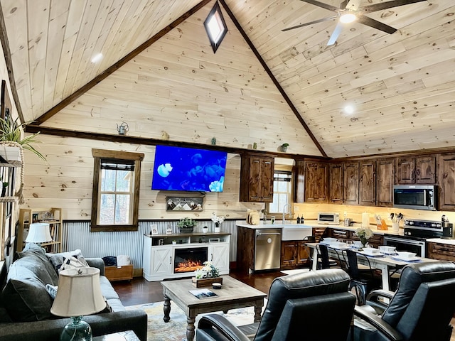 living area with wooden ceiling, dark wood finished floors, ceiling fan, high vaulted ceiling, and wooden walls