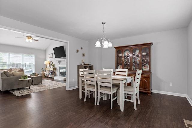 6837 Benwood Dr, Ooltewah, TN 37363 - dining area featuring dark wood-type flooring, a glass covered fireplace, ceiling fan, a chandelier, and baseboards