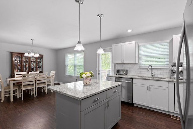 6837 Benwood Dr, Ooltewah, TN 37363 - kitchen with stainless steel appliances, a sink, dark wood-type flooring, a center island, and decorative backsplash
