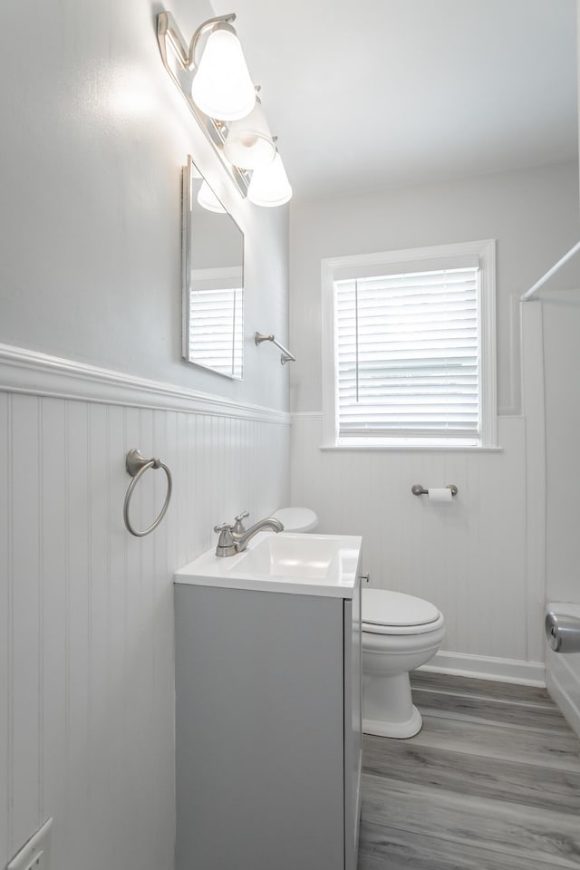 1641 John Ross Rd, Chattanooga, TN 37412 - bathroom featuring toilet, wood finished floors, a wainscoted wall, vanity, and a shower