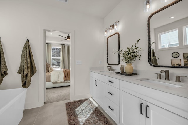 bathroom featuring double vanity, a freestanding tub, ensuite bath, ceiling fan, and tile patterned flooring