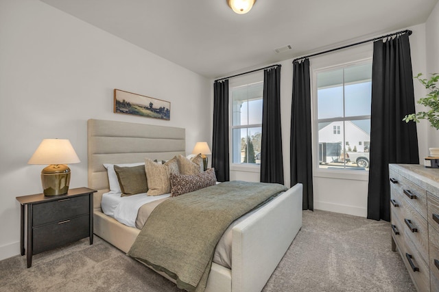 bedroom with light carpet and baseboards