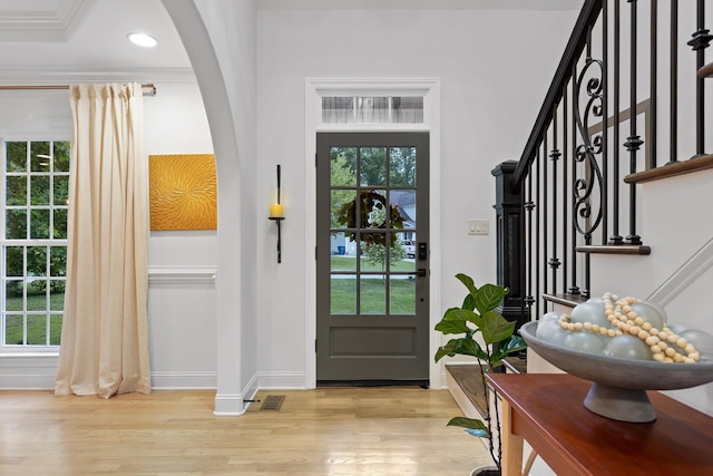 entryway with light wood-type flooring, baseboards, plenty of natural light, recessed lighting, and crown molding