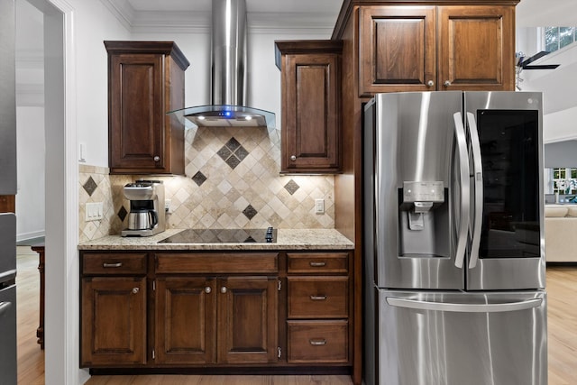 kitchen featuring stainless steel fridge with ice dispenser, wall chimney exhaust hood, black electric stovetop, light wood-type flooring, and decorative backsplash