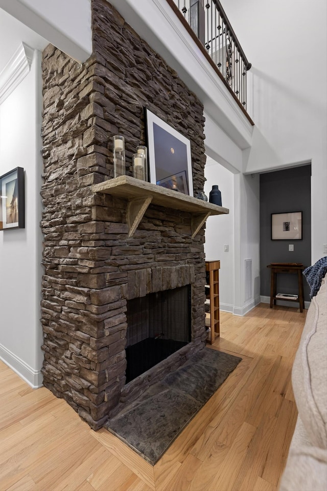 unfurnished living room featuring baseboards, wood finished floors, and a fireplace