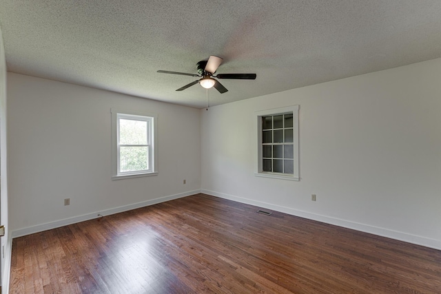 unfurnished room featuring a ceiling fan, dark wood finished floors, a textured ceiling, and baseboards