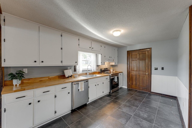 kitchen with appliances with stainless steel finishes, a sink, a textured ceiling, white cabinets, and under cabinet range hood