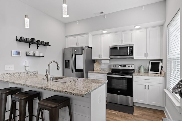 116 Paxtons Way, Ringgold, GA 30736 - kitchen featuring stainless steel appliances, open shelves, a peninsula, white cabinets, and a kitchen breakfast bar