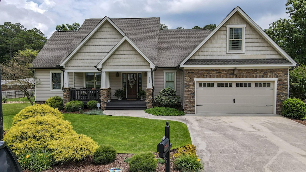 536 Clintons Pass NW, Cleveland, TN 37312 - craftsman-style home with a porch, concrete driveway, a front yard, stone siding, and roof with shingles