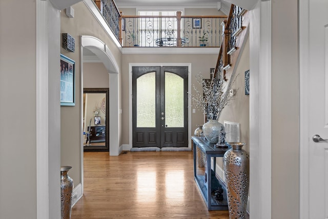8109 Propeller Dr, Ooltewah, TN 37363 - entrance foyer featuring a towering ceiling, wood finished floors, arched walkways, baseboards, and french doors