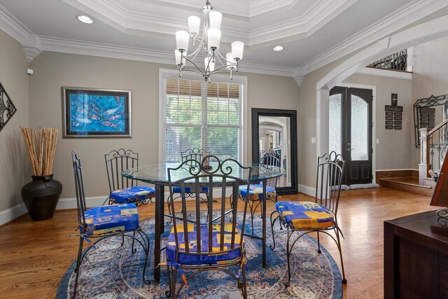 8109 Propeller Dr, Ooltewah, TN 37363 - dining room featuring arched walkways, plenty of natural light, a chandelier, wood finished floors, and crown molding