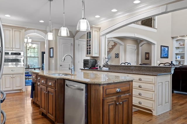 8109 Propeller Dr, Ooltewah, TN 37363 - kitchen featuring arched walkways, appliances with stainless steel finishes, a sink, a center island with sink, and crown molding