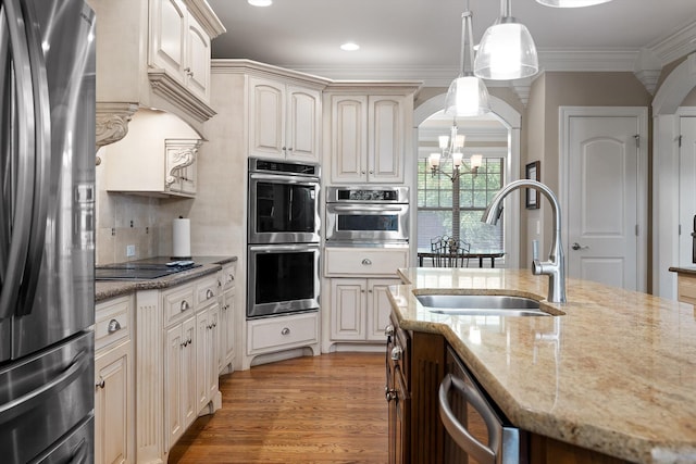 8109 Propeller Dr, Ooltewah, TN 37363 - kitchen with appliances with stainless steel finishes, a sink, a chandelier, arched walkways, and pendant lighting