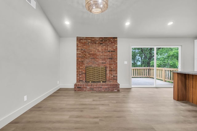 unfurnished living room with a fireplace, light wood-type flooring, recessed lighting, a chandelier, and baseboards