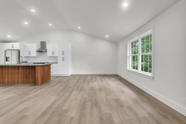 unfurnished living room featuring lofted ceiling, a sink, recessed lighting, light wood-style floors, and baseboards