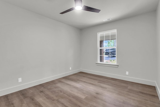 unfurnished room featuring ceiling fan, baseboards, and wood finished floors