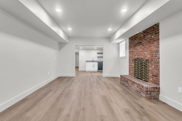 unfurnished living room featuring light wood-type flooring, recessed lighting, beverage cooler, baseboards, and bar area