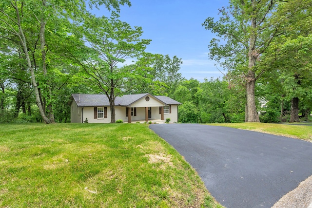 ranch-style house with asphalt driveway, a porch, and a front lawn