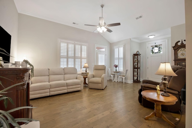 living area featuring a ceiling fan, lofted ceiling, wood finished floors, crown molding, and baseboards