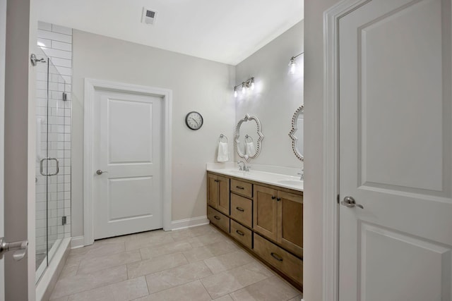 full bath featuring a shower stall, double vanity, and baseboards