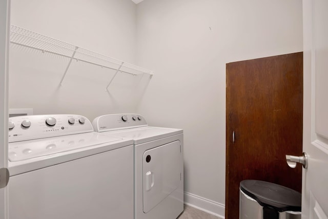 clothes washing area featuring washer and dryer and baseboards